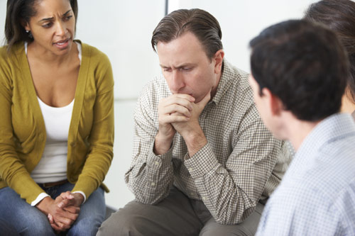 photo of a pensive man in a support group meeting