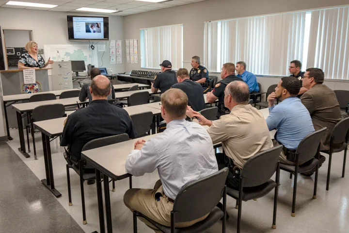 GCCFN outreach trainer standing before a room of law enforcement officers giving a presentation