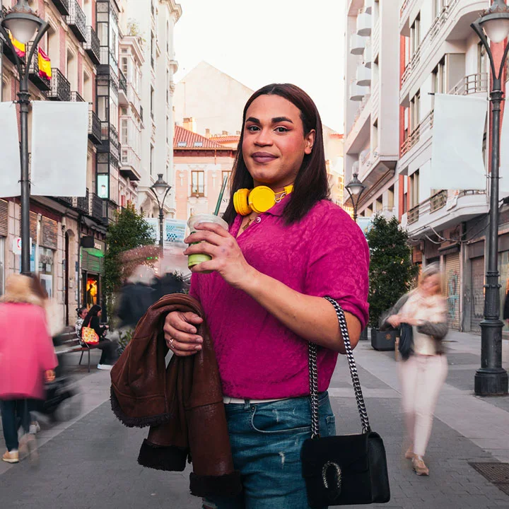 Portrait of trans woman and unrecognizable people walking close to her on a city street