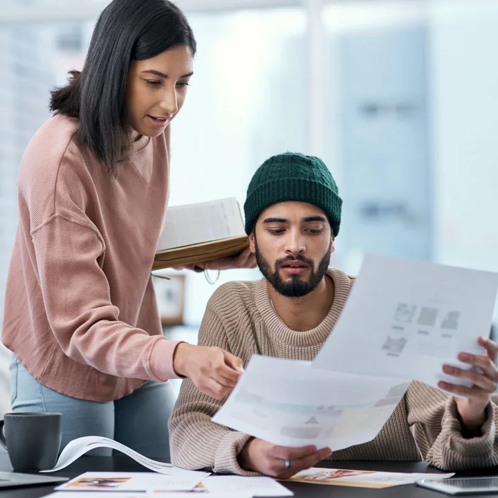 young man and woman having a discussion while looking at papers