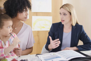 A case manager speaks with a young mother holding her child